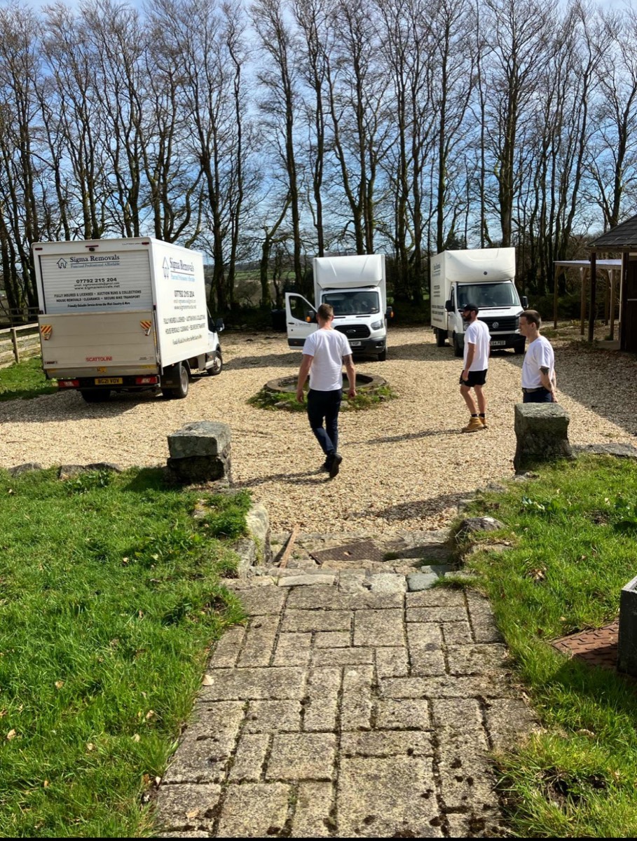 Sigma Removals team walking towards their fleet of Luton vans at a Devon countryside property