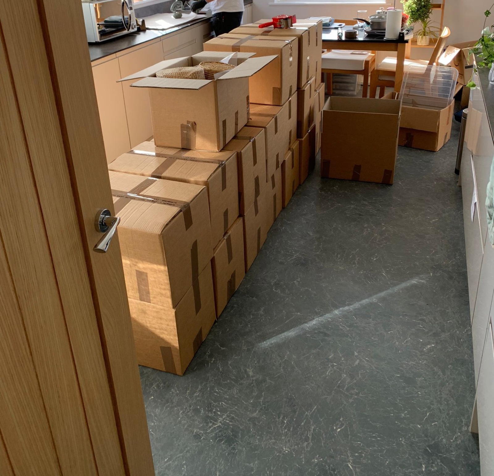 Neatly packed and labelled moving boxes stacked in a customer's kitchen ready for collection